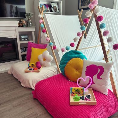 Cozy indoor teepee setup with colorful cushions and playful decorations.