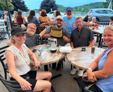 Group of friends gathered outdoors at a table for Trivia Cat Trivia