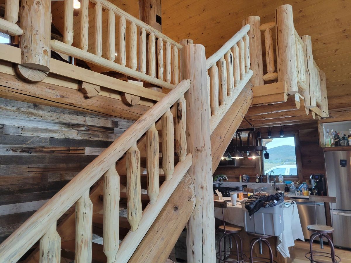 An image of a beautiful hand crafted log stair railing by M.B.C Log homes