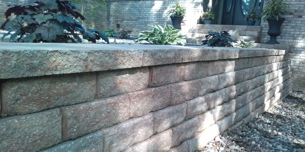 Versa Lok retaining wall with rock bed and front yard planter curb appeal drainage solutions