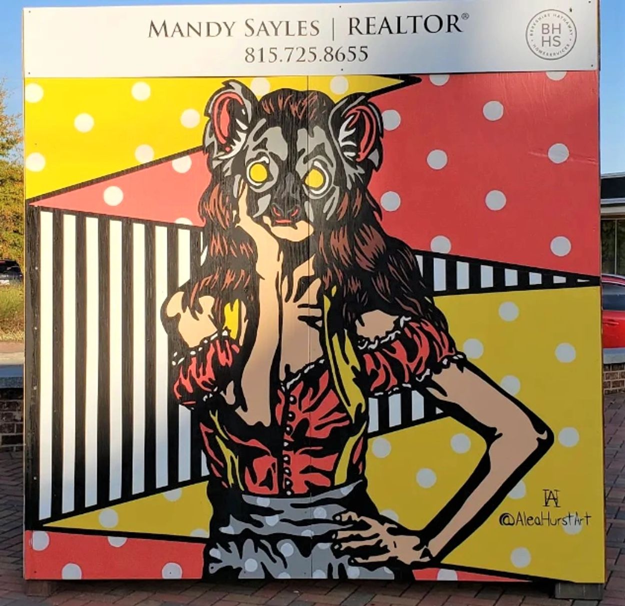 Colorful mural of a woman with a bear mask and vibrant geometric background.