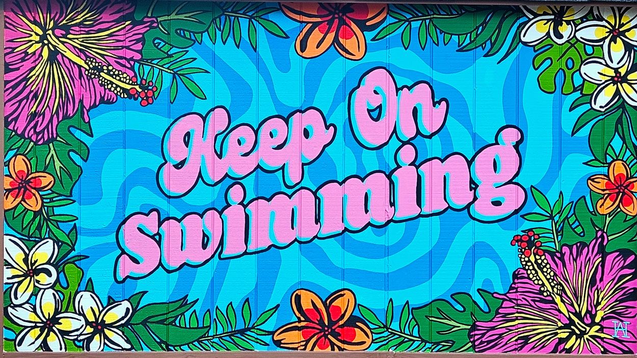 Colorful mural saying 'Keep On Swimming' surrounded by flowers.