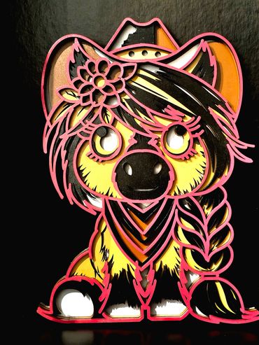 Colorful layered paper art of a cute dog with a cowboy hat and flower.