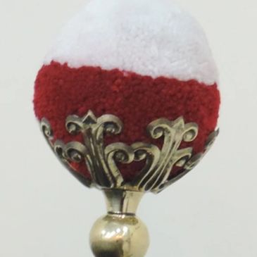 A ball tuft held in a brass leaf holder for shakos