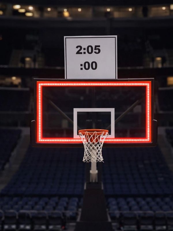 Close-up of a basketball hoop and net inside an empty arena.