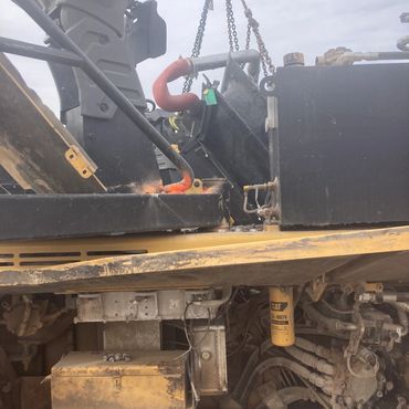 Close-up of heavy machinery engine with visible dirt and oil spill.
