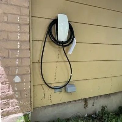 Wall-mounted electric vehicle charging station with neatly organized cable