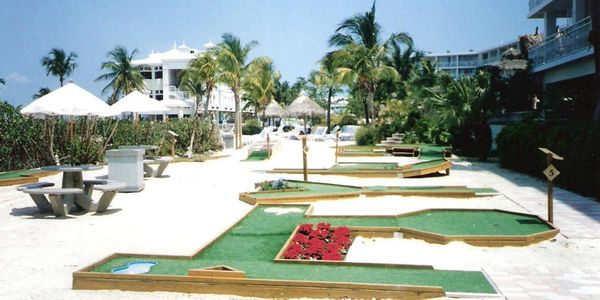 Outdoor mini golf obstacle course on sand.