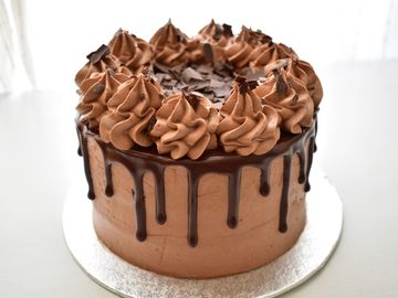 double chocolate cake with callebaut dark chocolate drip and chocolate flakes