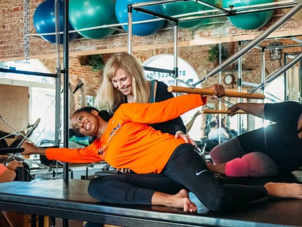 Jill assisting duet students with exercise on the Cadillac Trapeze Table.