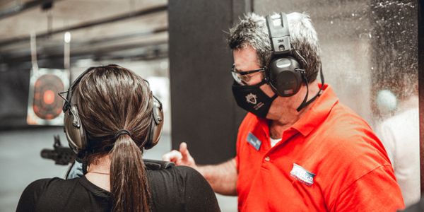 Knowledgeable staff training a customer with a firearm on the shooting range