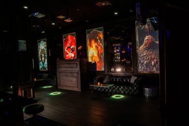 Dark lounge with illuminated modern art and cozy seating.