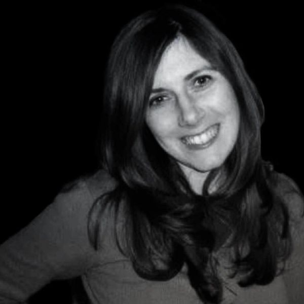 Smiling woman with long hair in black and white photo.