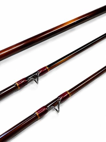 Close-up of three glossy fishing rod sections with guides.
