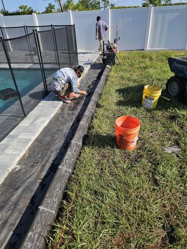 Workers making concrete curbing.