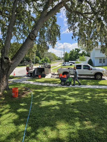 Our work truck, trailer, curbing equipment and tools, and crew members working.