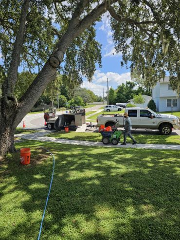 Our work truck, trailer, curbing equipment and tools, and crew members working.