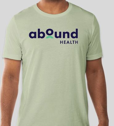 Light green t-shirt with Abound Health logo in navy and teal.