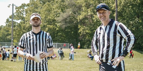 Referees smiling during halftime.