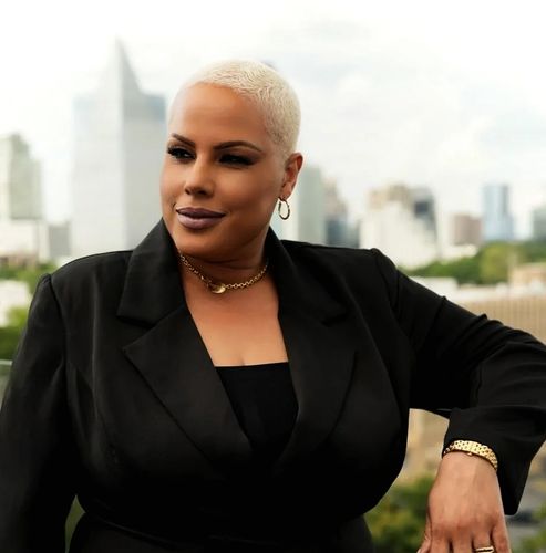Confident woman with short blonde hair in a black blazer.