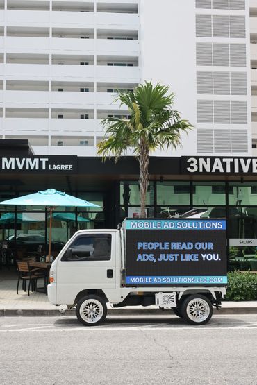 Small truck with mobile ad signage parked in an urban area.