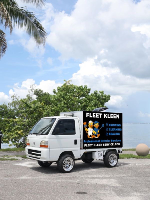 Small white truck with a Fleet Kleen advertisement.
