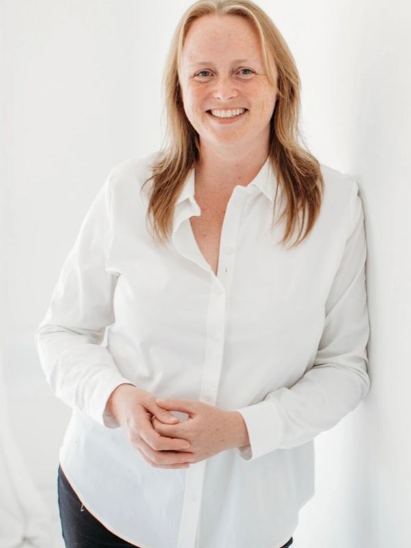 Smiling woman in a white shirt.
