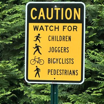 Caution sign warning to watch for children, joggers, bicyclists, and pedestrians.