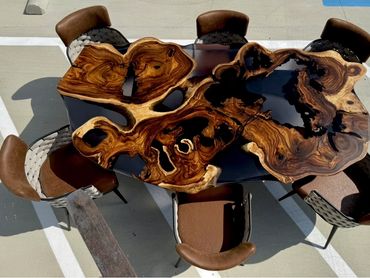 Unique wooden table with natural patterns and six chairs outdoors.
