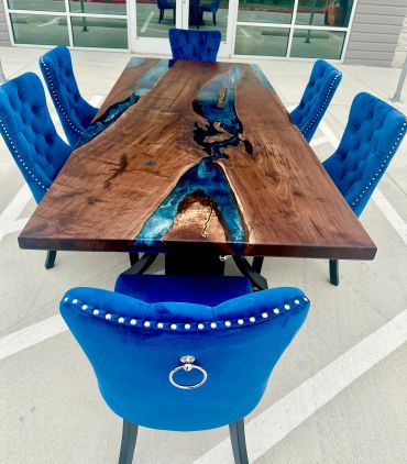 Elegant wooden table with blue epoxy resin and matching blue velvet chairs.