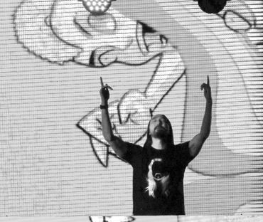 DJ and electronic music producer Steve Aoki with his hands in the air.