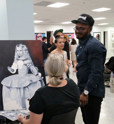 Artist doing live art with guest attending art exhibit in Miami at mindwarehouse