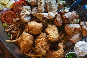 Caught fish platter with fish prepared 3 ways with veggies, fries, and tartar sauce