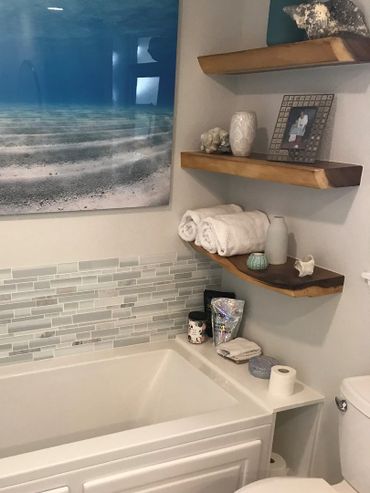 Close up of custom live edge floating shelves with pretty display of soaps and towels