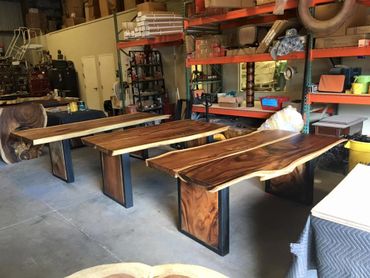 Fabrication warehouse showing 3 unique live edge slab wood tables being crafted by Decor Direct Team