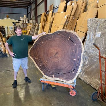 Decor Direct fabricator standing by a 5 foot round live edge cross cut slab on a cart in warehouse