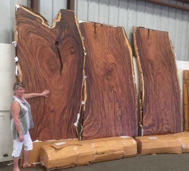 Customer stands by 3 massive 12 foot long live edge slab to be made into her custom kitchen counters