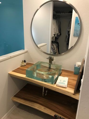 Custom two-level bath vanity floating between 2 walls in Venice FL with glass sink