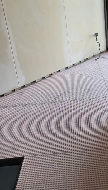 Room under renovation with new flooring and a cardboard box near the door.