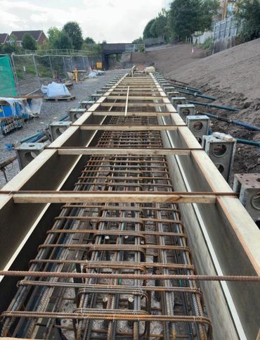Concrete formwork with steel reinforcement bars at a construction site.