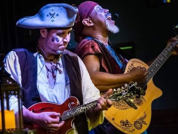 Two musicians passionately playing string instruments, one dressed as a pirate.