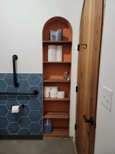 Custom designed built-in with arched top and wooden shelves.