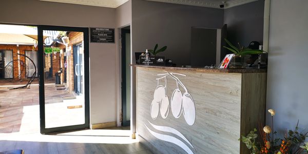 Reception area with a wooden desk and decorative flowers.