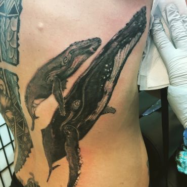 Tattoo of a whale and an octopus on skin.