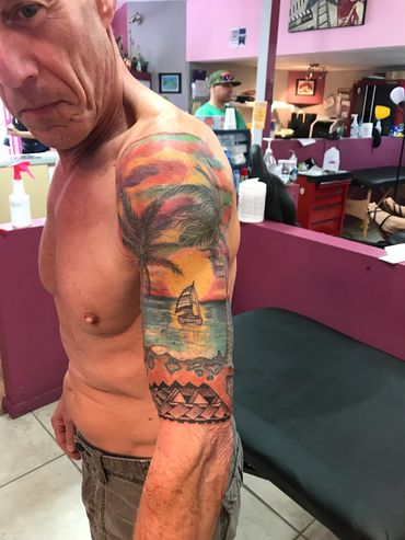 Man showing off colorful tropical tattoo on arm.