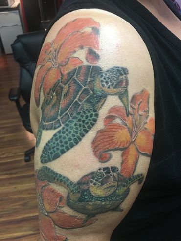 Turtle and orange lily tattoo on upper arm.