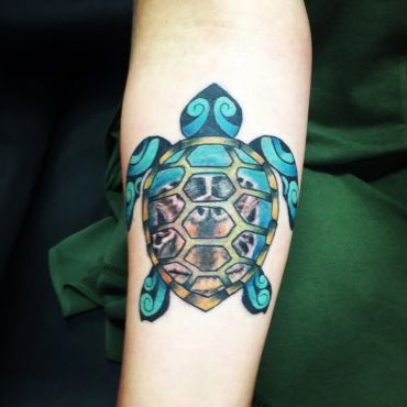 Brightly colored turtle tattoo on skin.