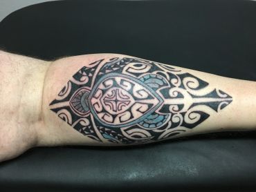 Tribal tattoo of a turtle on a forearm.