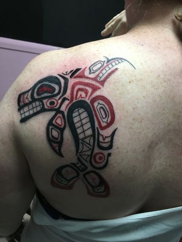 Tribal tattoo on upper back.