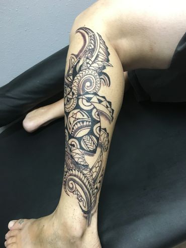 Intricate tribal tattoo on leg and calf.